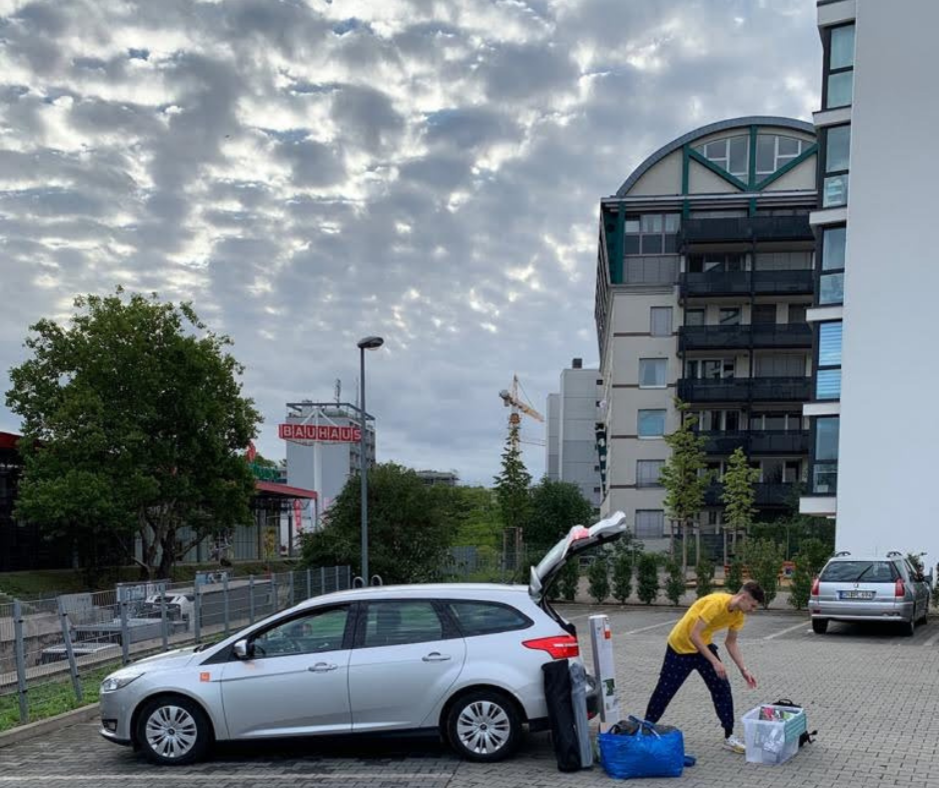 Ein Mann räumt den Kofferraum eines Autos aus