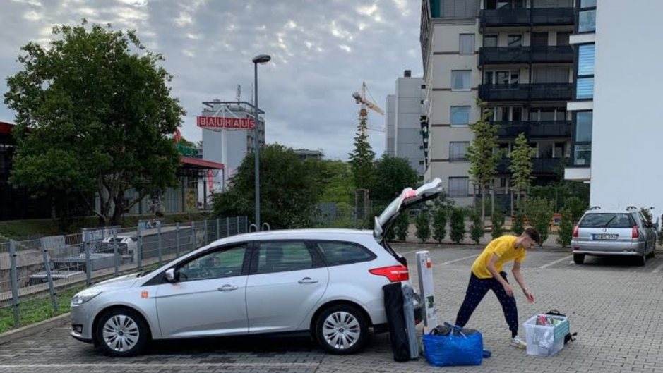 Ein Mann räumt den Kofferraum eines Autos aus