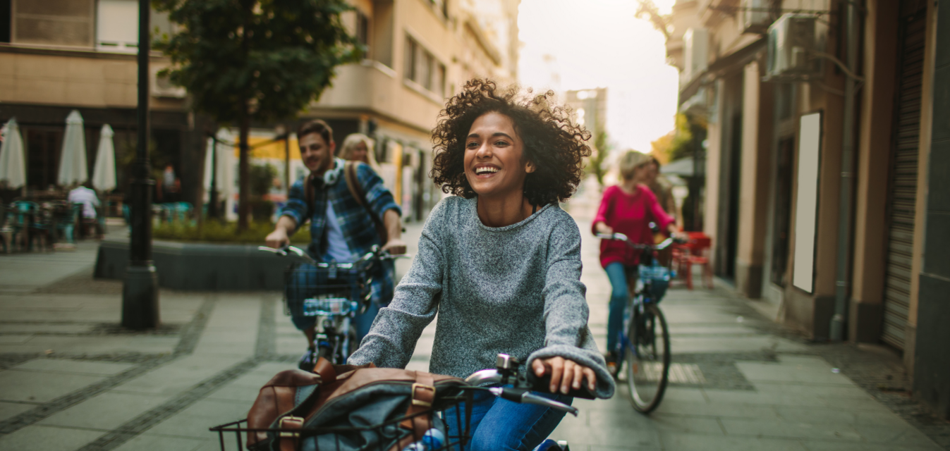 Ein Mann und zwei Frauen fahren auf dem Fahrrad durch die Innenstadt.