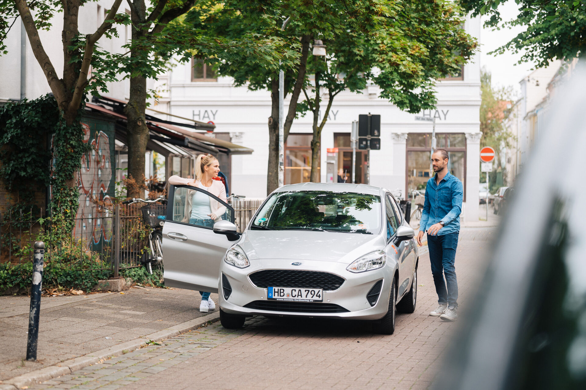 Mann und Frau beladen cambio-Auto in Bremer Wohnstrasse