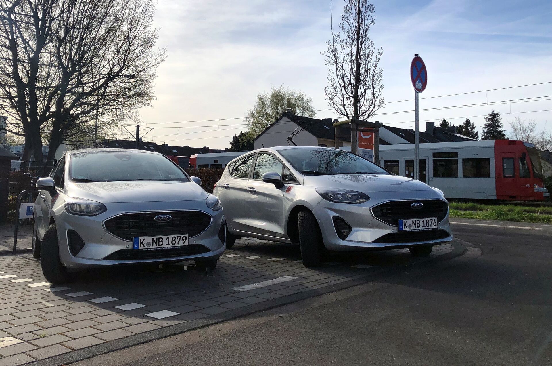 Zwei silberne Autos stehen etwas schräg auf einem Parkplatz.