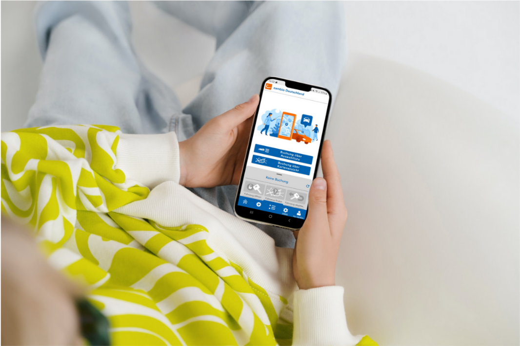 Person hält Smartphone mit der cambio-App in der Hand.