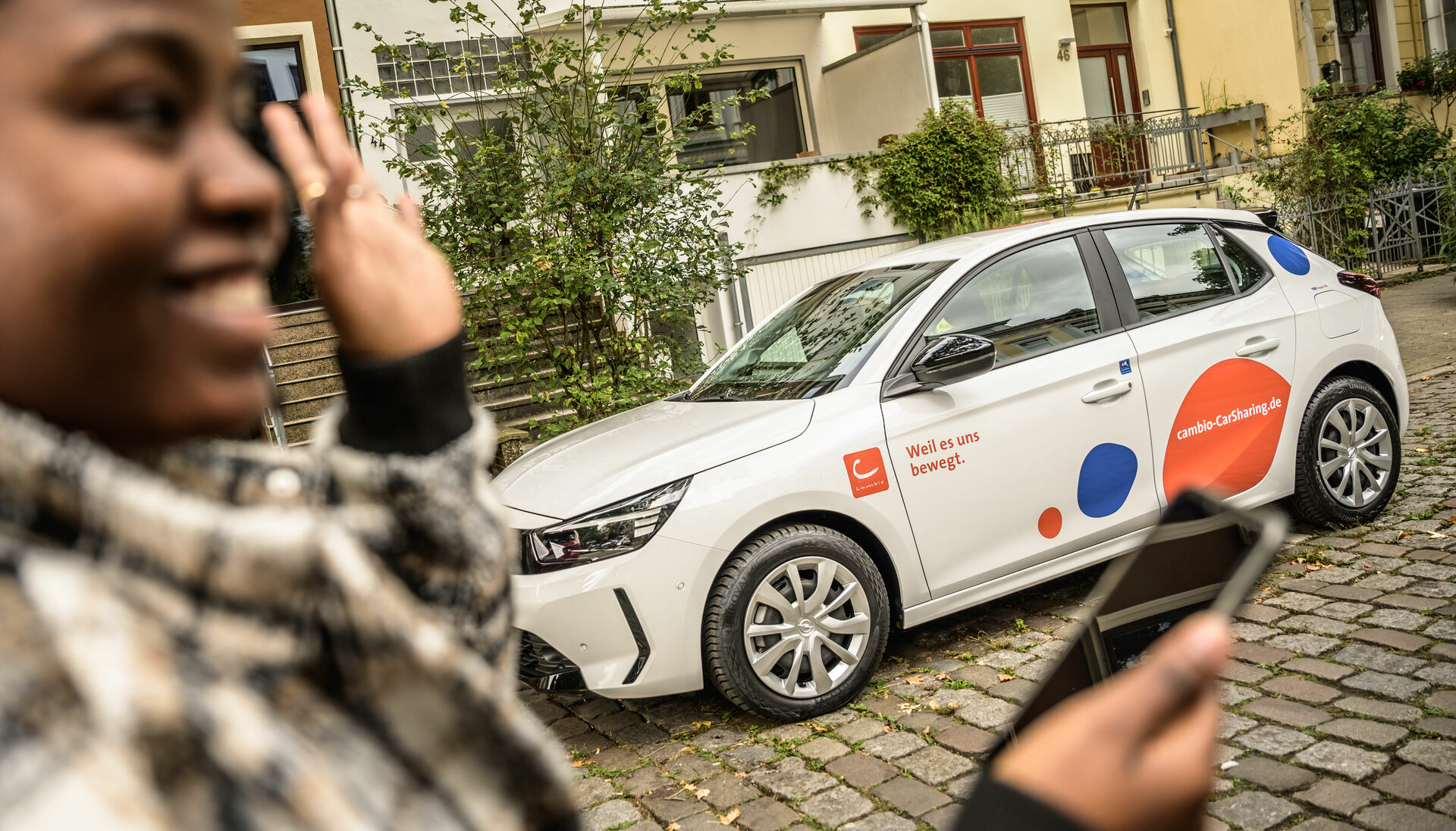 Eine junge Frau am cambio-Auto.
