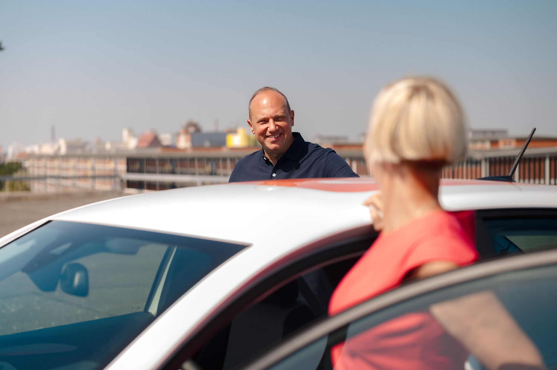 Eine Frau und ein Mann steigen in ein Auto ein.
