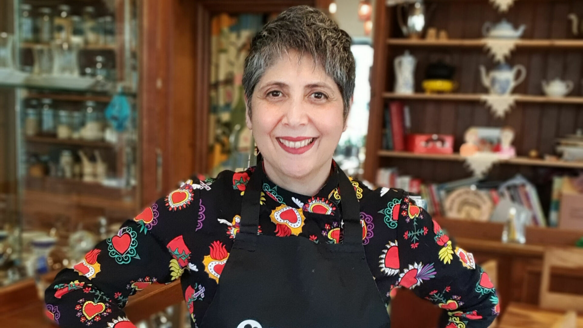 Frau mit Kochschürze lächelt in Kamera