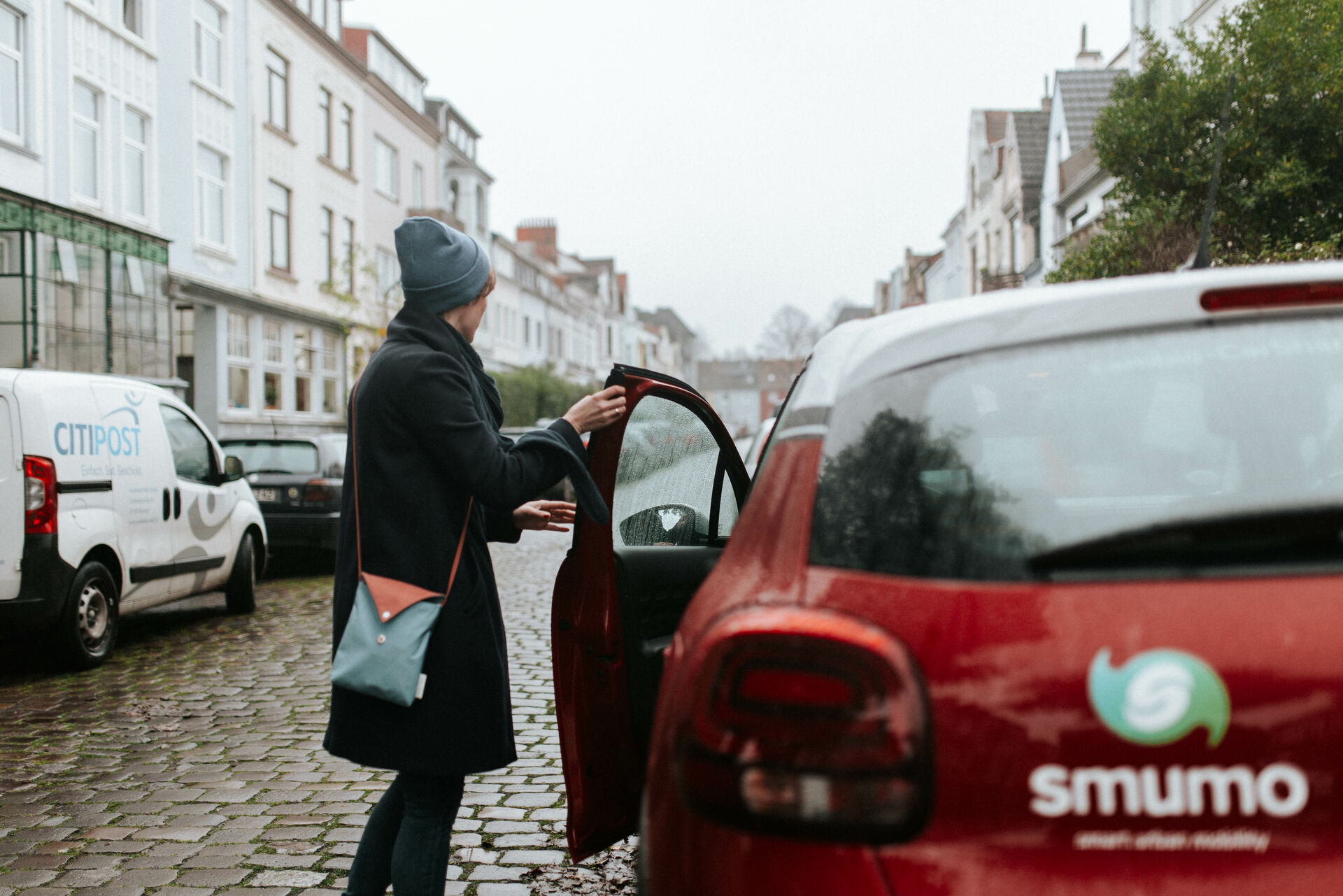 Frau steht an der offenen Wagentür eines smumo