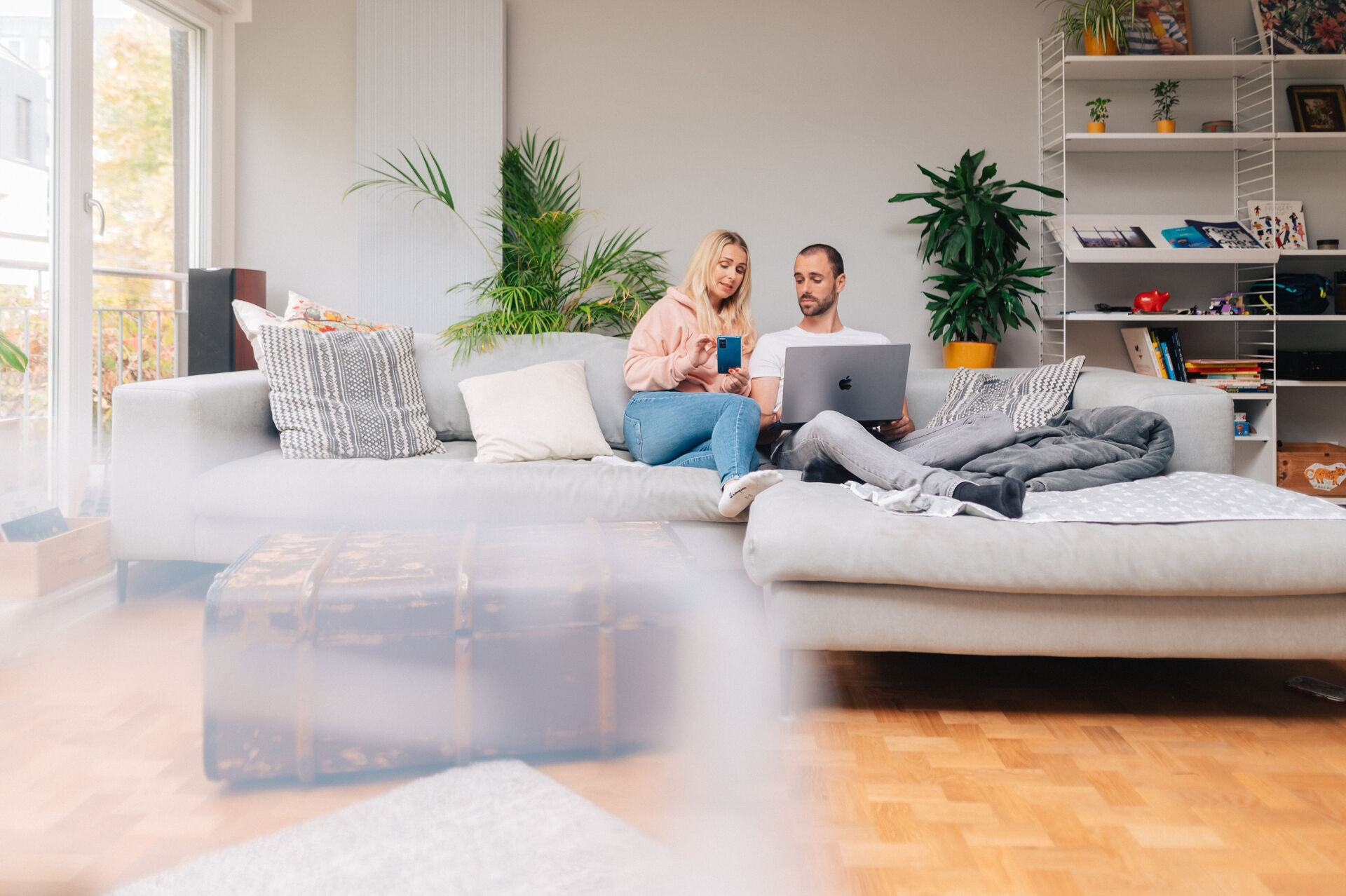 Mann und Frau sitzen auf Sofa und schauen auf Laptop