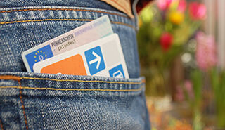 Hosentasche einer Jeans von hinten, daraus lugen eine cambio-Karte und ein Europäischer Führerschein.
