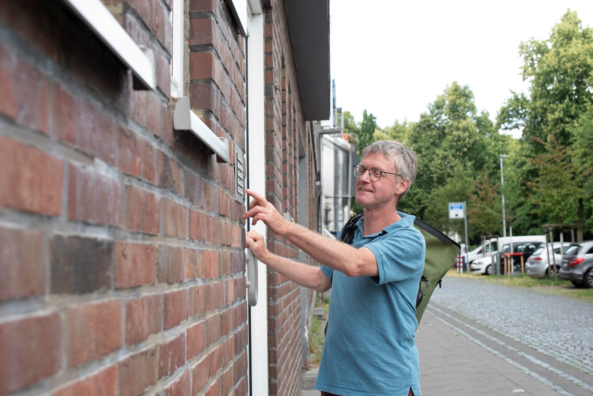 Ein Mann klingelt an der Haustüre eines Reihenhauses
