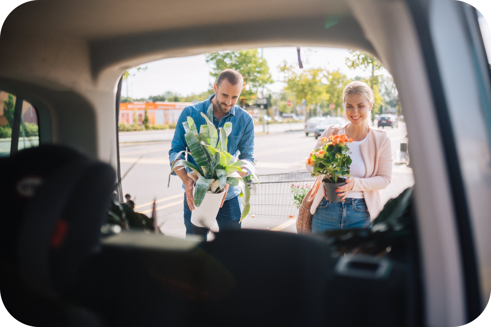 Eine Frau und ein Mann laden Pflanzen in den Kofferraum