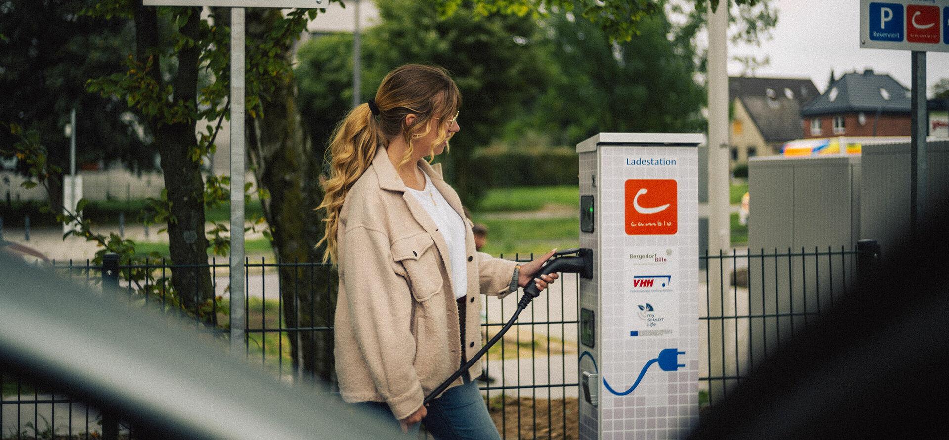 Frau lädt cambio-Auto an Station