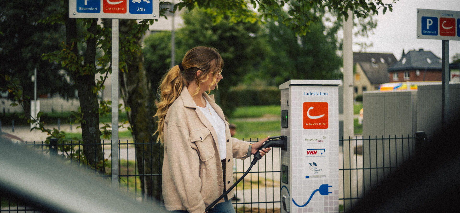 Frau lädt cambio-Auto an Station