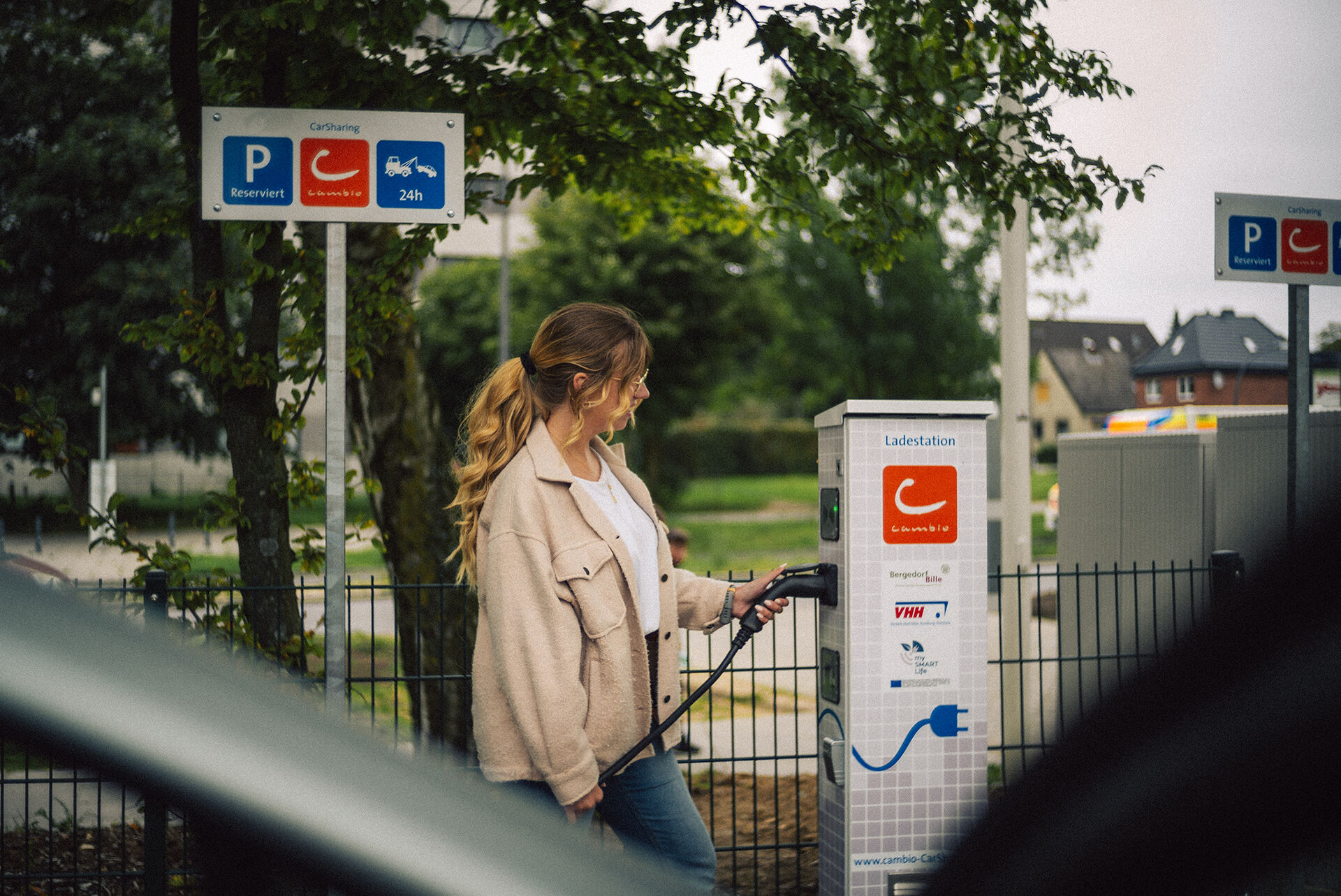 Frau lädt cambio-Auto an Station