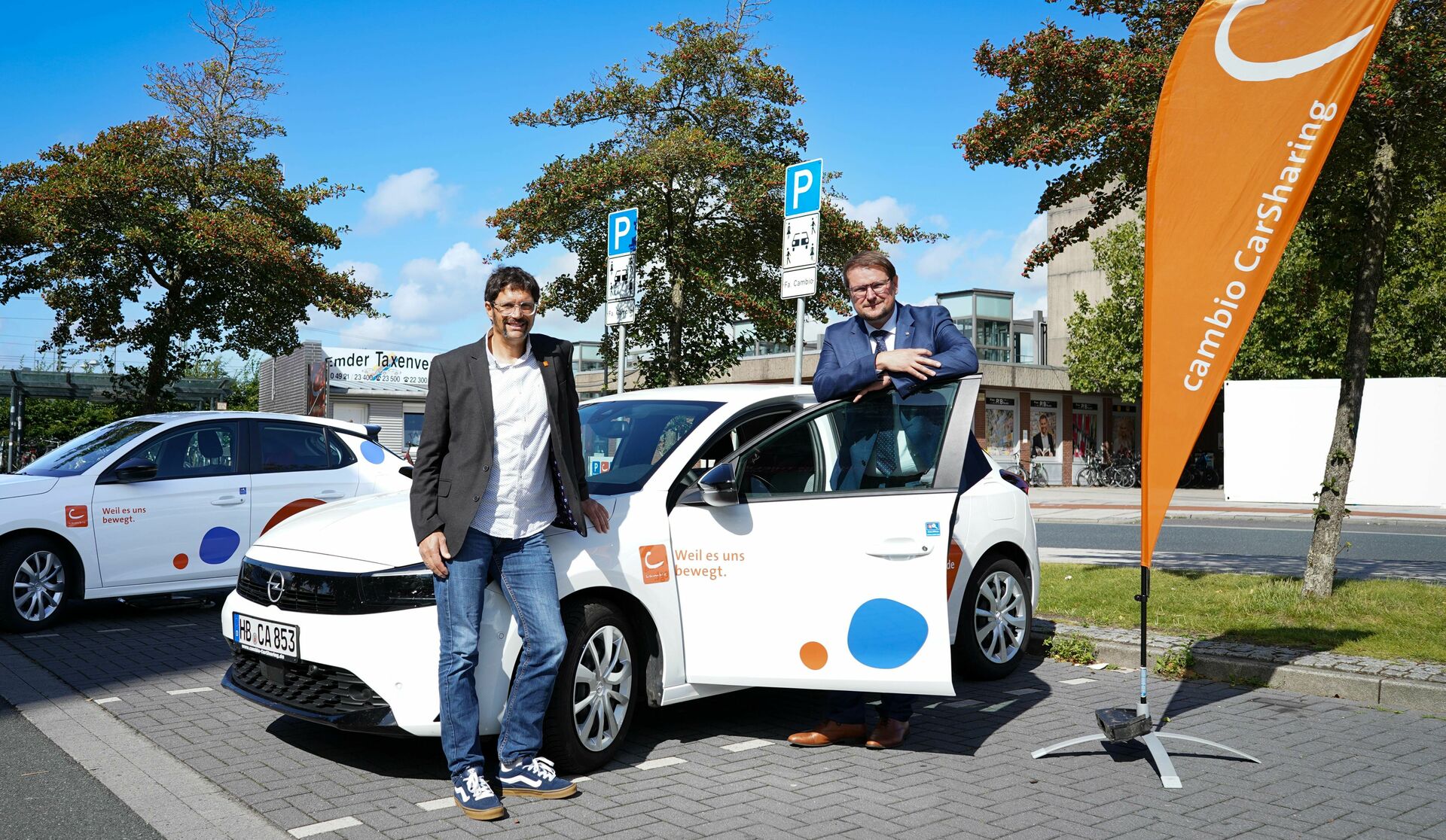 Fleming Erdwiens von cambio und Oberbürgermeister Tim Kruithoff stehen an einer CarSharing-Station in Emden