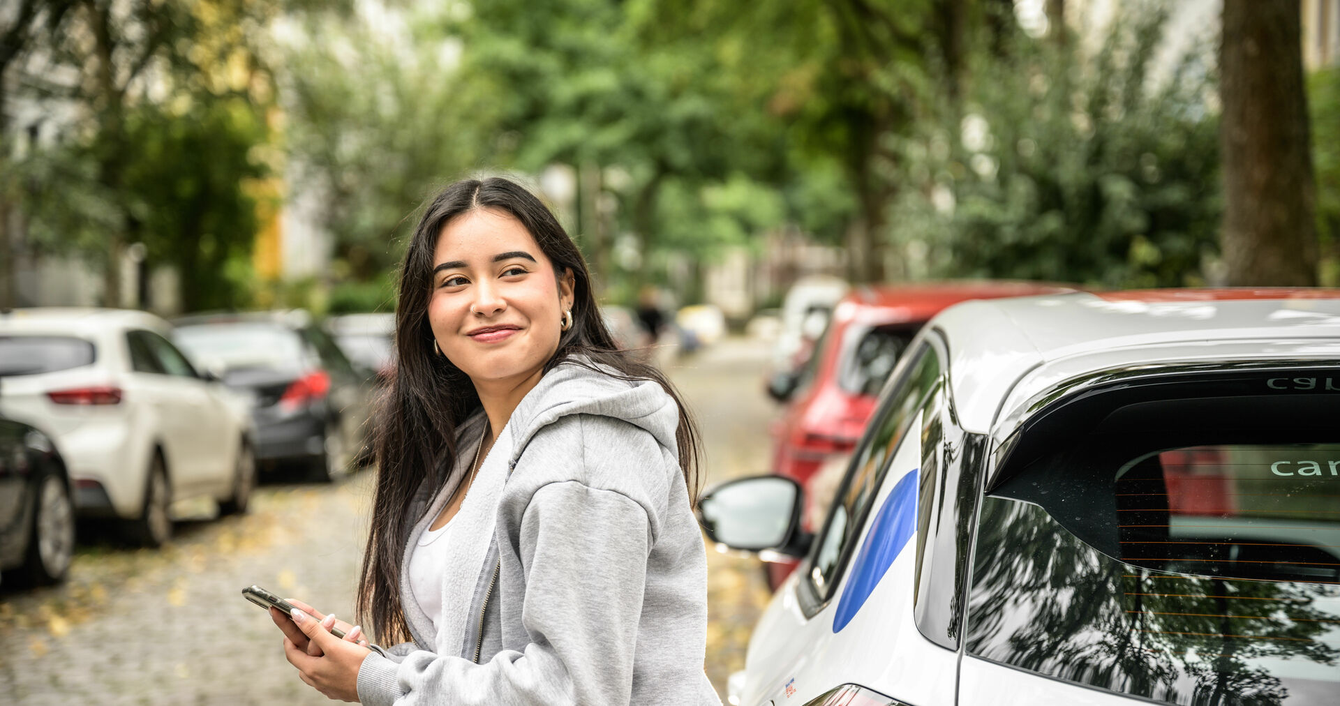Eine junge Frau am cambio-Auto.