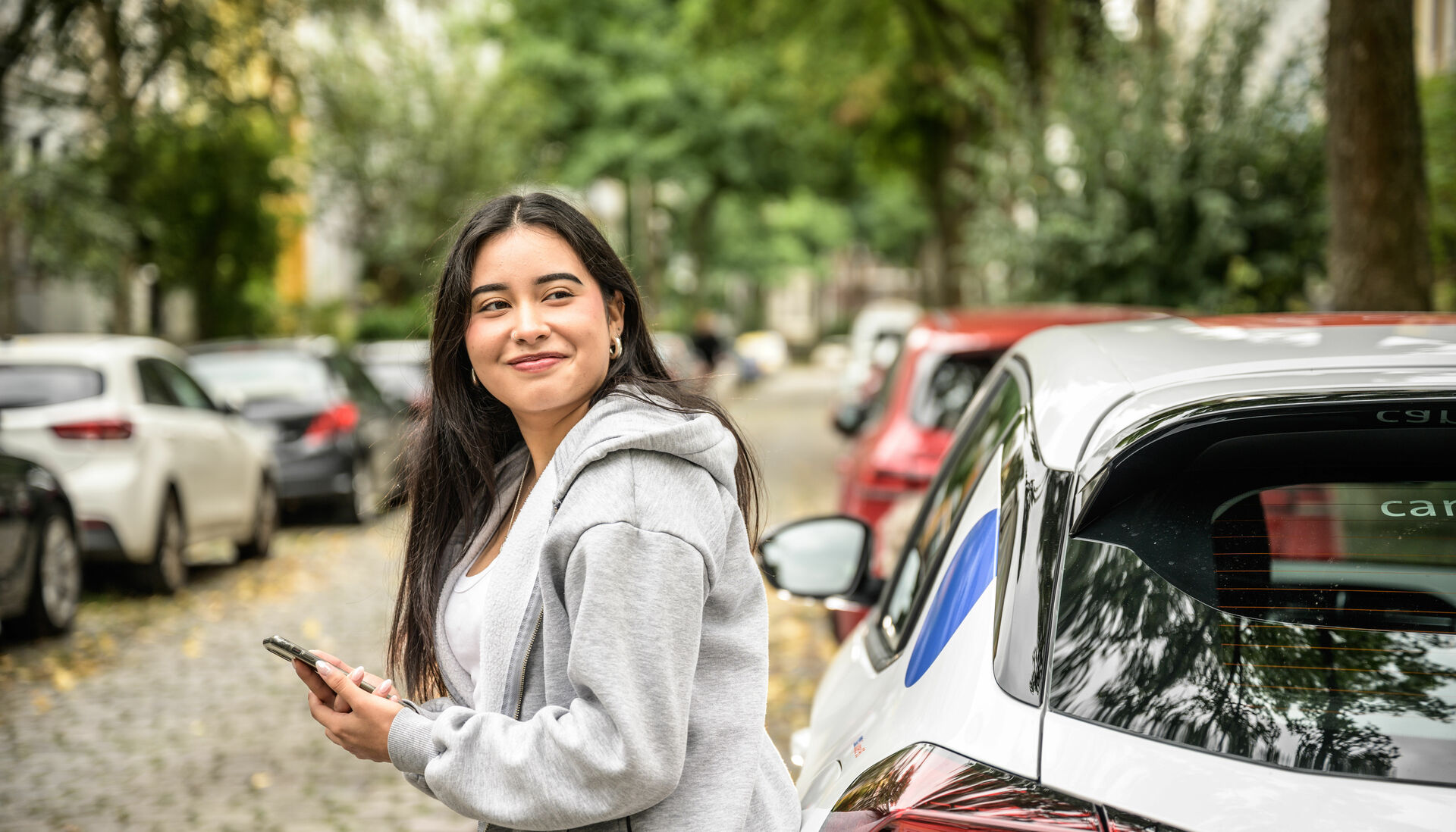 Eine junge Frau am cambio-Auto.
