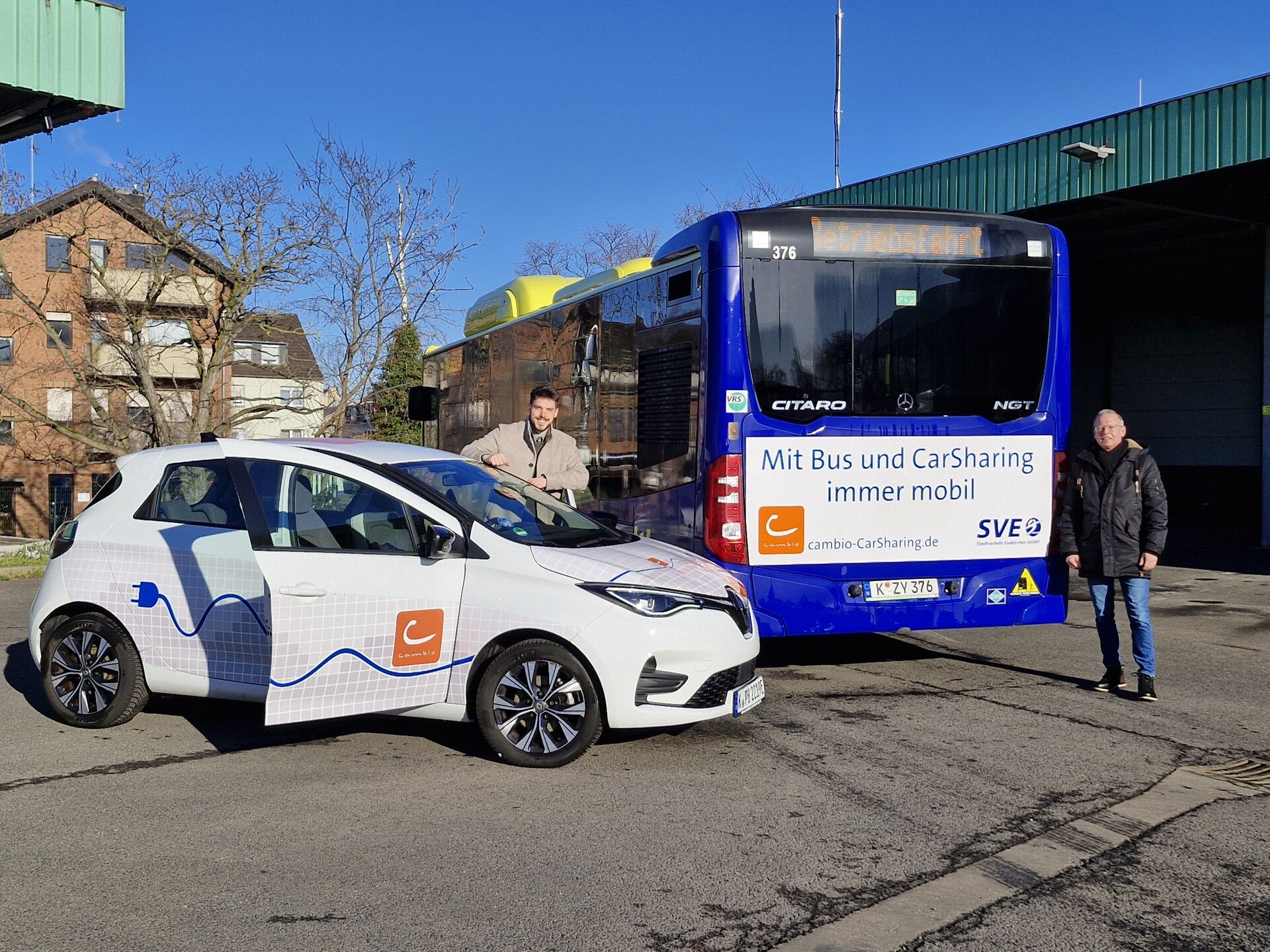 E-Auto von cambio steht neben einem Bus der SVE.