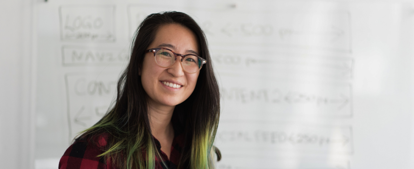 Frau mit Brille lächelt freundlich in die Kamera.