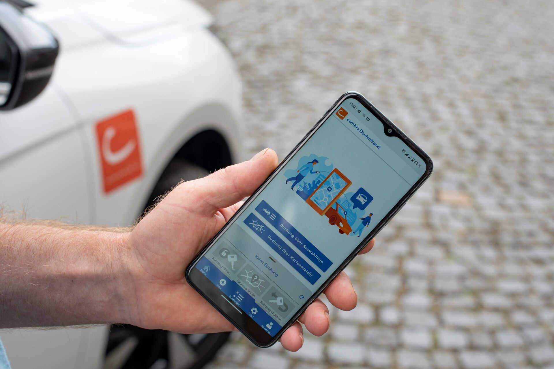 Hand mit Smartphone und darauf geöffneter cambio-App