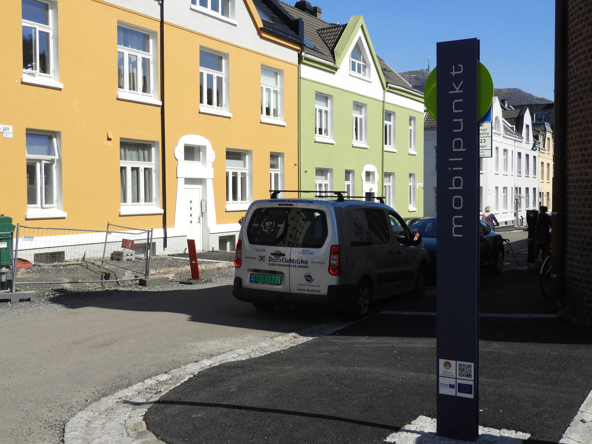 Straßenszene. Im Vordergrund ein Schild: mobilpunkt